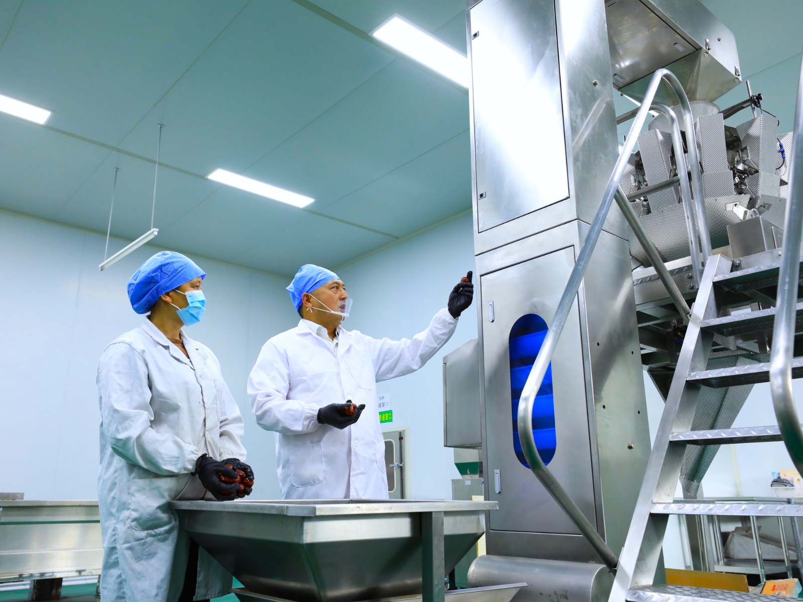 圖為駐村隊員正在指導風兮果園員工正確使用干果分選機姚煜峰攝