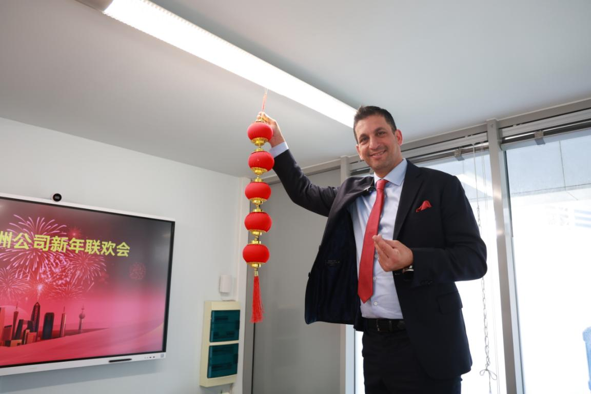 5日,國華投資歐洲公司希臘籍員工約阿基姆在辦公區掛燈籠,貼春聯。